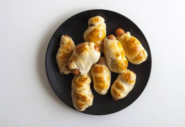 Masadaki seramik tabakta hamurdaki sosisler..