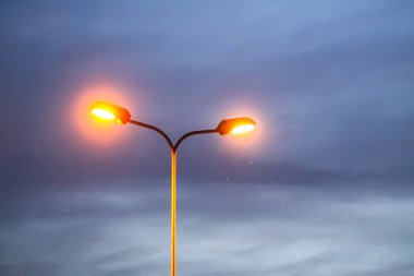 Gece gökyüzüne karşı bir sıra sokak lambası.