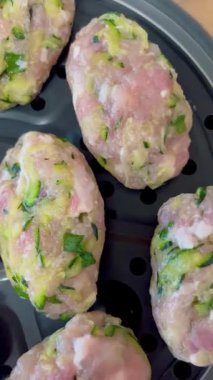 Çiğ tavuk ve kabak köfteleri bir buharlı tencerede. Sağlıklı ev yapımı yemekler yemek için hazır. Temiz malzemelerin yakın çekim videosu ve mutfak düzeninde yeni hazırlıklar..