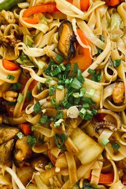 Yakın plan, soya soslu pirinç eriştesi ve deniz ürünleri. Bir Asya restoranında öğle yemeği..