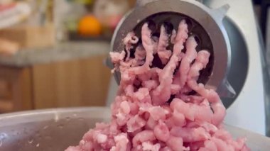 Çiğ tavuk ve domuz eti öğütücüsünde öğütülmüş. Taze kıyma iplikler halinde geliyor. Mutfak malzemeleri. Yüksek kalite 4k görüntü