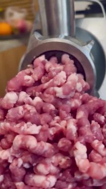 Çiğ tavuk ve domuz eti öğütücüsünde öğütülmüş. Taze kıyma iplikler halinde geliyor. Mutfak malzemeleri. Yüksek kalite 4k görüntü