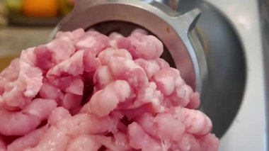 Çiğ tavuk ve domuz eti öğütücüsünde öğütülmüş. Taze kıyma iplikler halinde geliyor. Mutfak malzemeleri. Yüksek kalite 4k görüntü