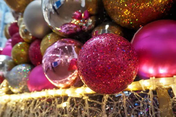 Büyük parlak yuvarlak altın, pembe ve gri Noel oyuncakları Noel ağacında asılı. Yan görünüş. Yüksek kalite fotoğraf