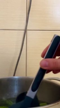 Mutfakta maşayla pişirilmiş yeşil kuşkonmaz sapları çekme işlemi. Sağlıklı yemek. Öğle yemeği için sebze pişiriyorum. 