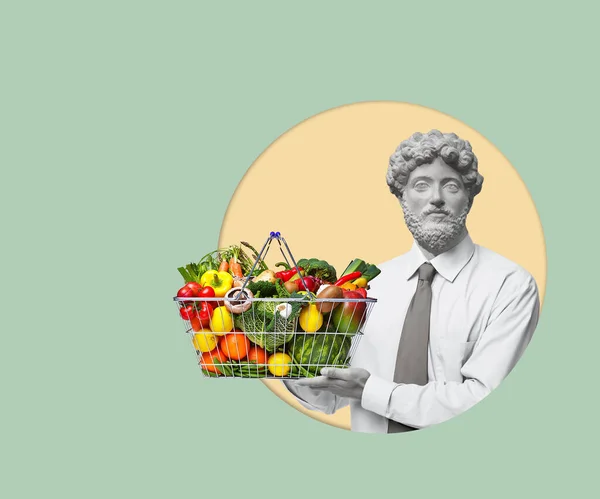 Contemporary art collage of a man headed by a statue head holding a shopping basket with fruits and vegetables. Healthy food concept. Modern design. Copy space for ad.