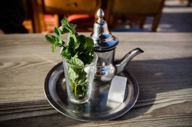 Geleneksel Fas çay demliği, dışarıda bir bardak su içmeye hazır.