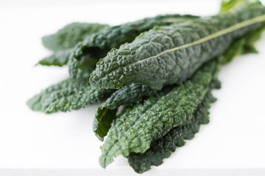 Fresh black kale leaves close up on a white background. Fresh organic farmers salad clipart