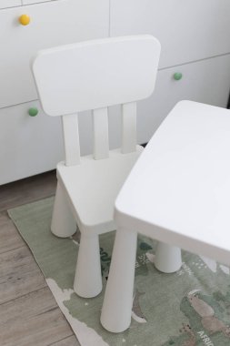 İçi beyaz çocuk masası ve sandalyesiyle aydınlık.