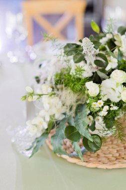 Süslü ve kağıt kartlı bir masada yeşil ve beyaz çiçekli çiçek kompozisyonu. Düğün partisi dekor konsepti