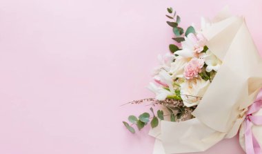 Beautiful bouquet with roses, carnations, iris and eucalyptus on a pink background, copy space. Mothers day, 8 march, holiday gift concept