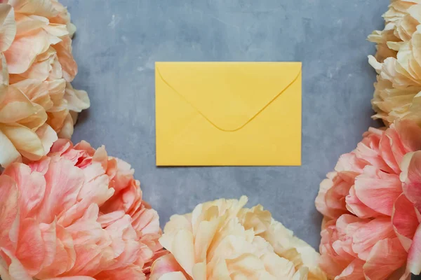 Beautiful Coral Peonies Yellow Envelope Grey Concrete Background Gift Card — Stockfoto