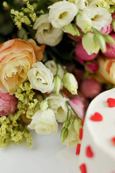 白い背景に赤いハートの装飾が施されたバラ リアンサス ホワイトケーキの明るい花束 — ストック写真