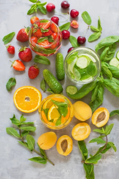 stock image Fresh summer fruit cocktails. Set of summer drinks on grey concrete background. Mocktails with strawberry, cherry, cucumber, basil, apricot, orange and mint