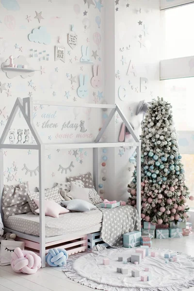 クリスマスの時間に白い壁に家の形のベッドと青とピンクの装飾が施されたかわいい子供部屋のインテリア 子供部屋の美しいクリスマスツリー — ストック写真