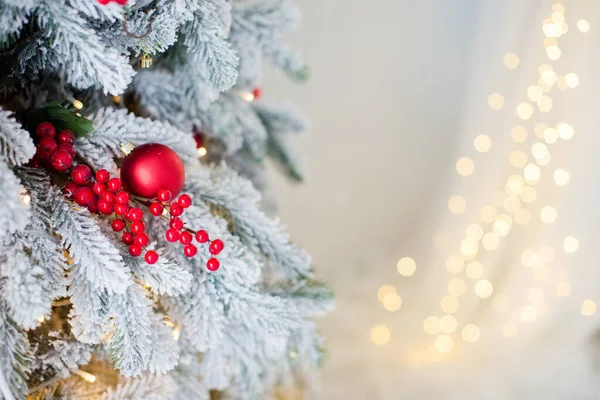 圣诞树的背景是红球装饰 红浆果枝条和舒适的灯饰 有复制空间的圣诞横幅 图库图片