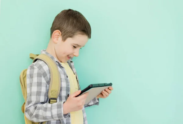 Kavkazský Chlapec Školní Batoh Drží Tablet Zeleném Pozadí Kopírovacím Prostorem — Stock fotografie