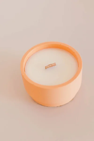 stock image Orange craft candle in concrete form at light background