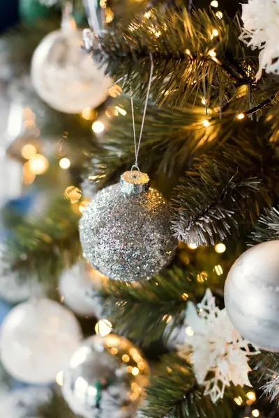 Gümüş ve beyaz süslemeleri olan güzel bir Noel ağacı Işıltılı ve sıcacık Noel çelengi