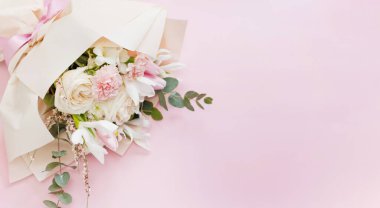 Beautiful bouquet with roses, carnations, iris and eucalyptus on a pink background, copy space. Mothers day, 8 march, holiday gift concept