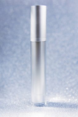 Işıltılı arka plan modelinde gümüş kozmetik şişe