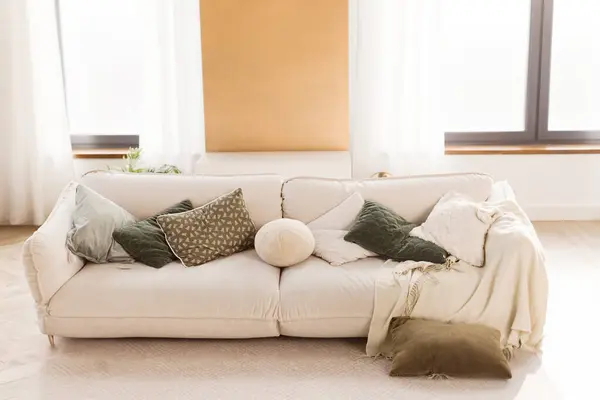 Light room with white sofa with pillows