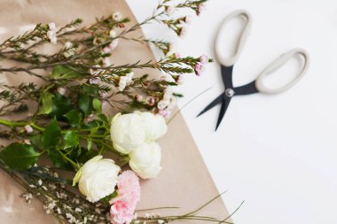Fotokopi alanı olan beyaz arkaplanda çiçekler ve makas, buket yapıyor.