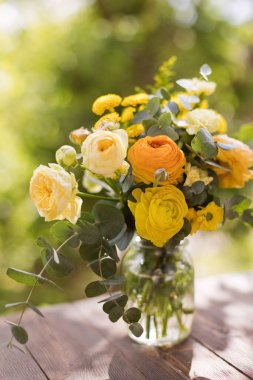 Güllü sarı buket, ranunculus, kasımpatı ve okaliptüs.