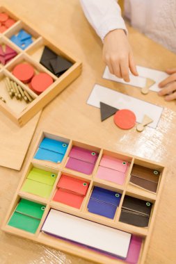 Renkli şekiller ve ahşap malzemelerle Montessori öğrenme etkinliği