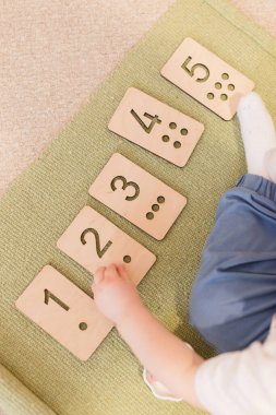 Montessori tahta kart ve noktalarla etkinlik sayıyor