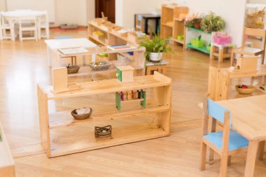 Ahşap rafları, eğitici oyuncakları ve öğrenme materyalleri olan Montessori sınıfı.