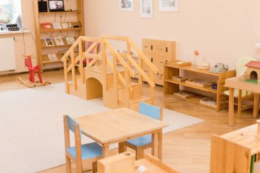 Tahta mobilyalar, öğrenme materyalleri ve oyun alanları olan Montessori sınıfı