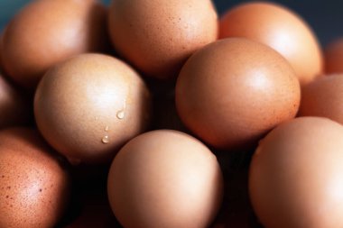 Yığılmış renkli yumurtalar, üzerine su serpilmiş.