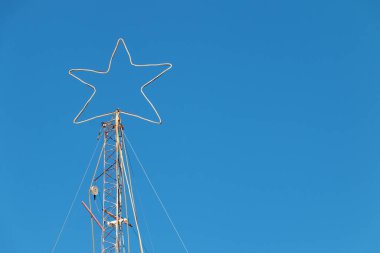 Yılbaşı gecesi için beyaz bir yıldız demir bir yapının tepesinde aydınlatacak. Gün ortasında açık gökyüzünün arka planı parlak mavi renkte olacak.