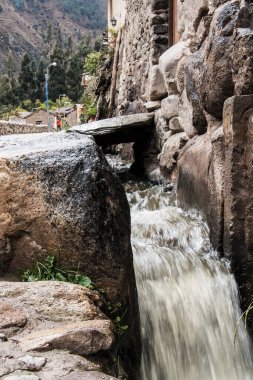 Hendek, hidrolik kanal ya da Ollantaytambo Peru 'daki İnka İmparatorluğu' na ait antik bir taş duvarın yanındaki su kemeri.. 