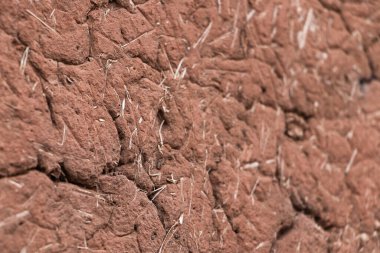 Antika doğal organik kerpiç duvarı. Kuru otla karıştırılmış. Yakın çekim ve nokta odaklı.