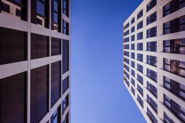 Arka planda mavi gökyüzü olan modern ofis binaları