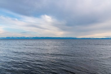 Mountains and grey clouds over the ocean during sunset