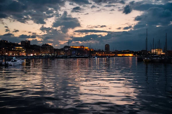 Marsilya, FRANCE - 12 Kasım 2021 - Gece Marsilya 'daki Eski Liman' ın karanlık sularına yansıyan gökyüzü