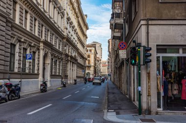 Trieste, İtalya - 21 Ağustos 2019 - Trafiği ve park halindeki araçları olan tipik dar sokaklar