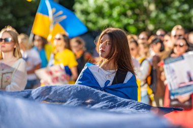 Vancouver, Kanada - 6 Haziran 2023 Ukraynalı partizan kız Ukrayna 'daki Rus savaşını ve baraj patlamasını protesto etmek için mavi bir bez tutuyor.