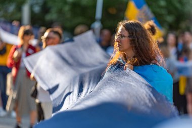 Vancouver, Kanada - 6 Haziran 2023 Ukraynalı partizan kız Ukrayna 'daki Rus savaşını ve baraj patlamasını protesto etmek için mavi bir bez tutuyor.