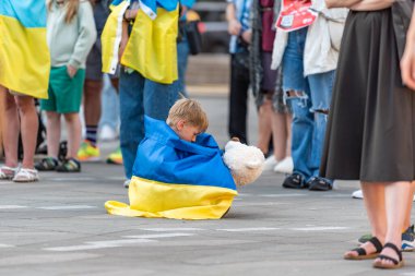 Vancouver, Kanada - 6 Haziran 2023 Ukrayna 'da savaş karşıtı protestolar sırasında oyuncak ayısıyla sahada gezen çocuk. Tahmini 1,5 milyon çocuk depresyon, endişe, travma sonrası stres bozukluğu ve diğer zihinsel sağlık sorunları riski altında.