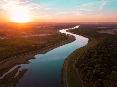 Nehirdeki su günbatımı ışınlarını yansıtıyor.