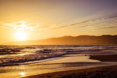 Santa Monica sahilinde gün batımı Pasifik Okyanusu 'nun sularına yansıyan güneş ışınlarıyla