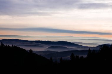 Dağın tepesinde sisli gün batımı