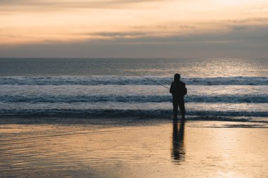 Fisherman's silhouette in the light of sunset