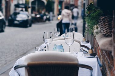 Şehir merkezindeki restoran masasında boş şarap kadehleri.