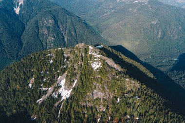 Ormanla kaplı yüksek dağ ve hala karla kaplı küçük alanlar.