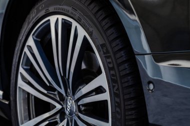 Audi sembolü ve lastik lastiği olan tekerleğin yakın görüntüsü.